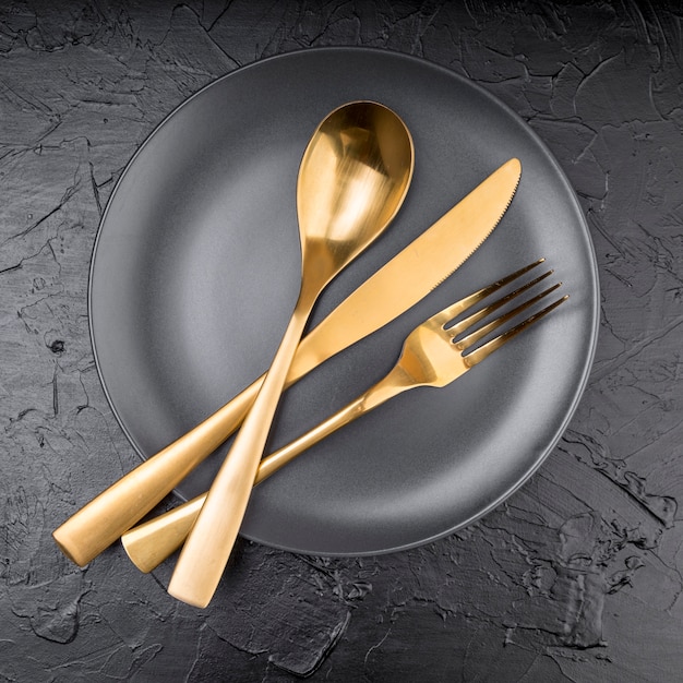 Top view of plate with golden cutlery