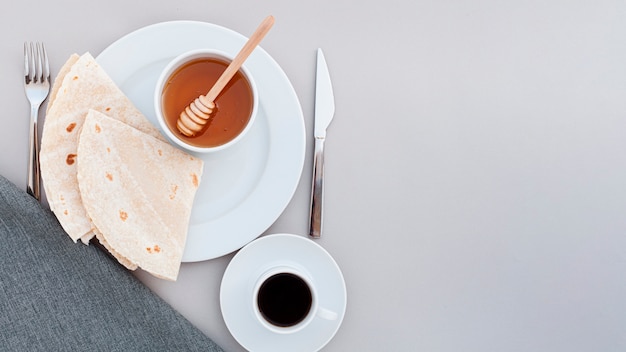 Top view plate with honey and tortilla