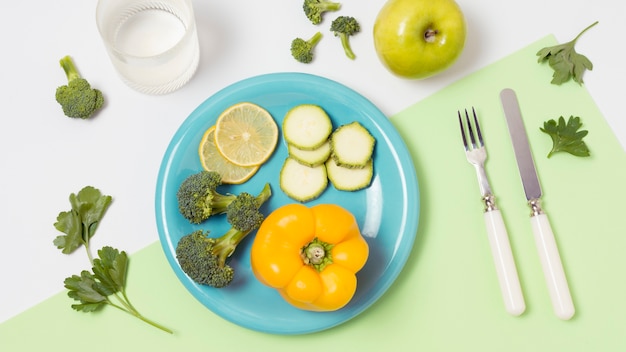 Вид сверху тарелка с органическими овощами на столе