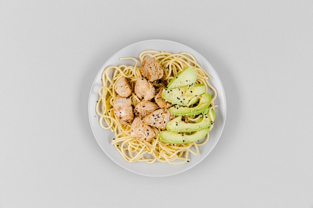 Top view of plate with pasta and avocado