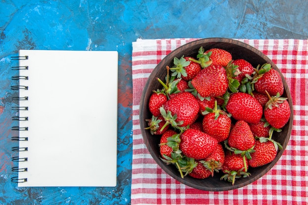 Top view plate with strawberries fresh tasty fruits on blue background