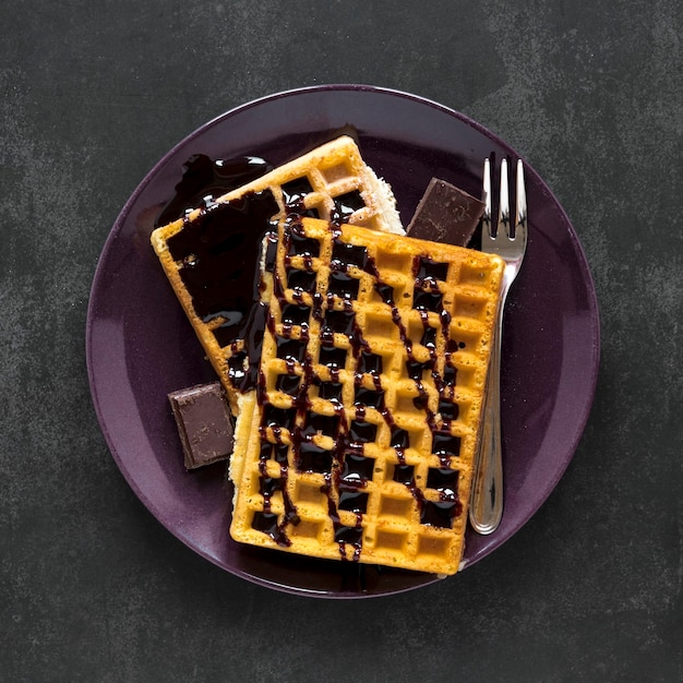 Free photo top view of plate with waffles and chocolate sauce