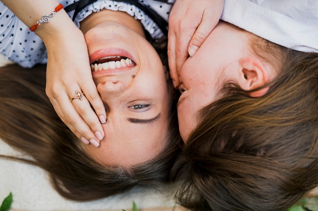 Free photo top view playful girls covering their faces