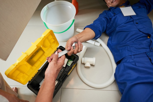 Free photo top view of plumber checking the kitchen fixtures