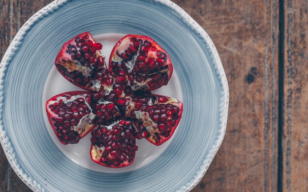 Free photo top view of pomegranate in bowl on wood