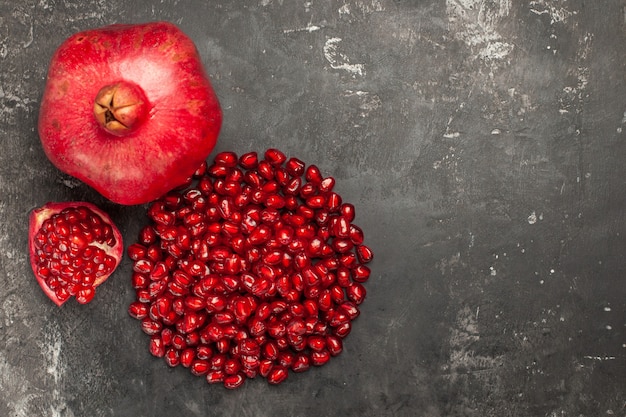 Top view of pomegranate pomegranate seeds on dark surface