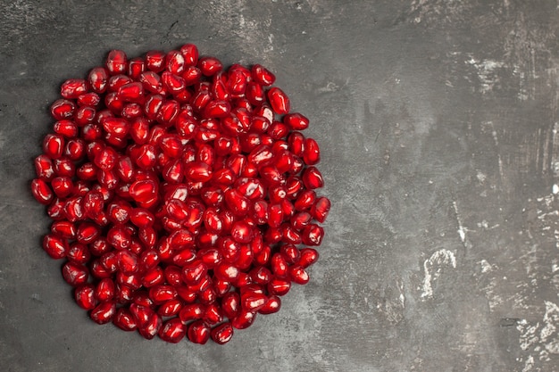 Free photo top view of pomegranate seeds on dark surface