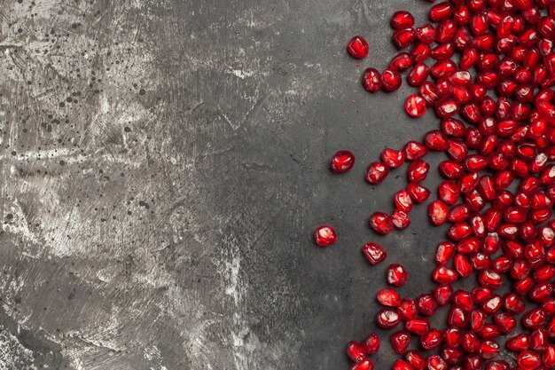 Top view of pomegranate seeds on dark surface