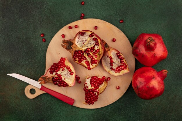 Top view pomegranate slices on cutting board with knife