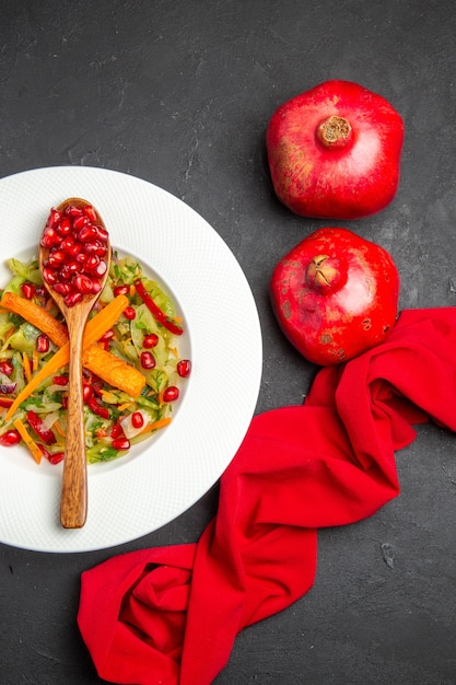 Top view pomegranate vegetable salad spoon with seeds of pomegranates tablecloth