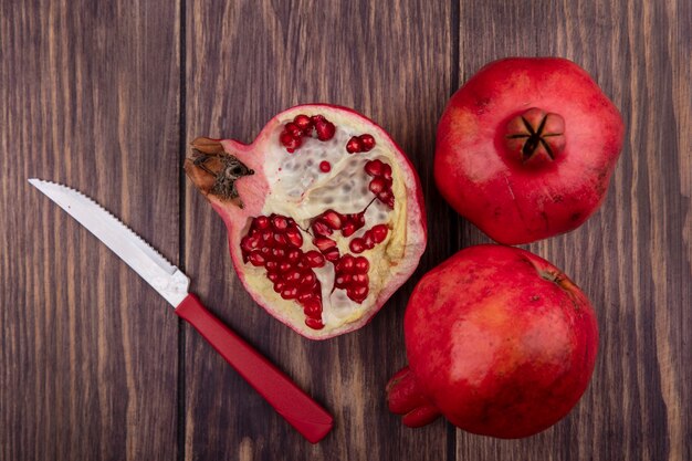 Top view pomegranate with a knife on a wooden table