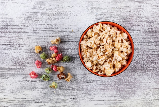 Top view of popcorn in bowl on white wooden  horizontal