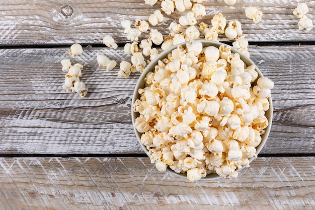 Top view of popcorn in bowl on white wooden  horizontal