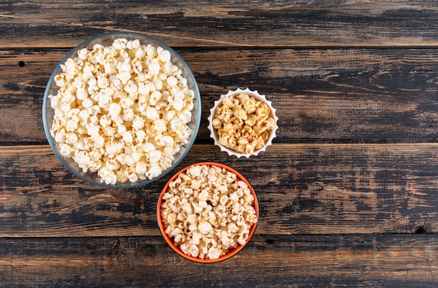 Vista superiore di popcorn in ciotole su orizzontale di legno scuro