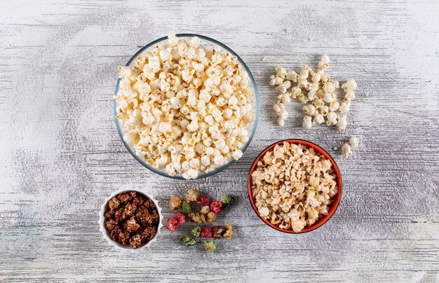 Top view of popcorn in bowls on white wooden  horizontal