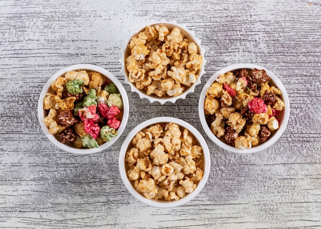 Free photo top view of popcorn in bowls on white wooden  horizontal