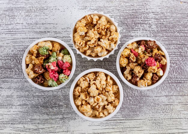 Top view of popcorn in bowls on white wooden  horizontal