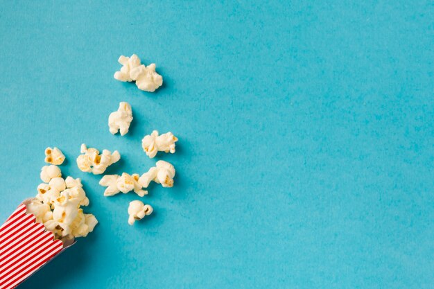 Top view popcorn composition on blue background with copy space