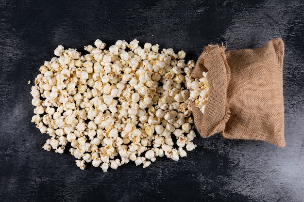 Top view of popcorn in sackcloth bag on black  horizontal