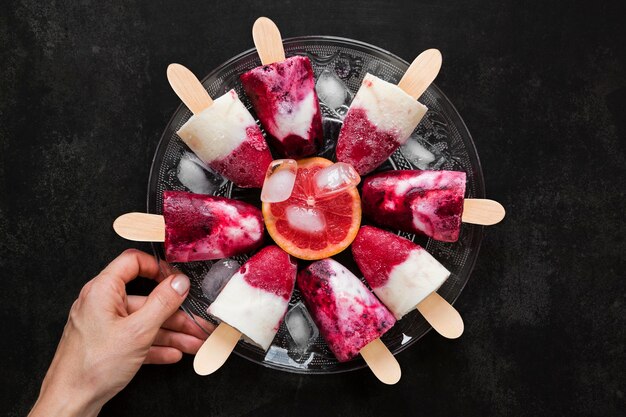 Top view of popsicles with red grapefruit and ice