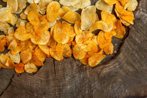 Top view of potato chips on a wood