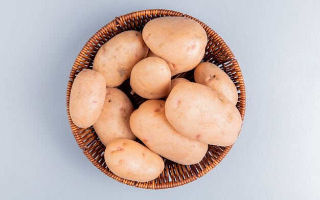 Top view of potatoes in basket on blue