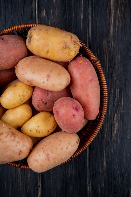 top view of potatoes in basket on wooden surface