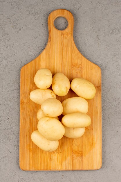 top view potatoes peeled out whole on the grey background