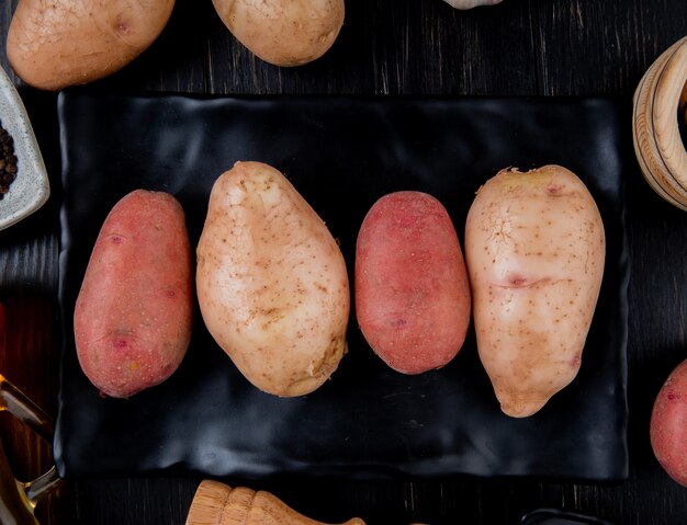 Top view of potatoes in plate and on wooden surface