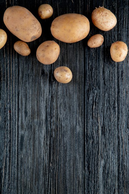 Top view of potatoes on wooden background with copy space