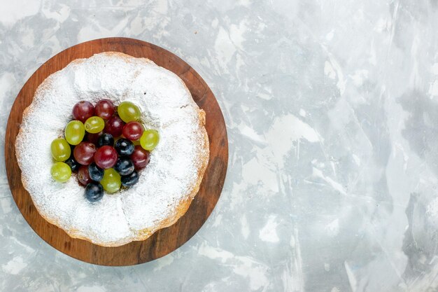 Top view  powdered cake delicious baked cake with fresh grapes on the white desk