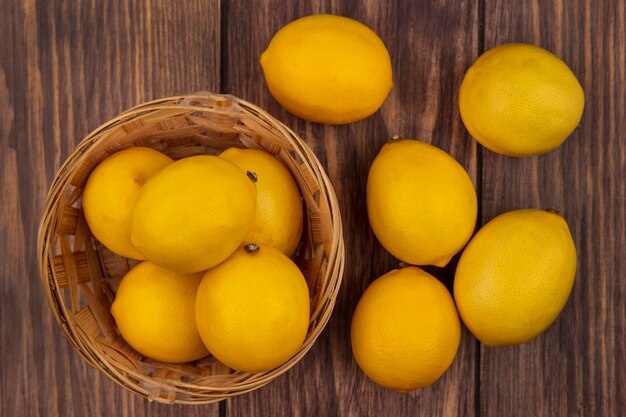 Top view of a powerful antioxidant lemons on a bucket with lemons isolated on a wooden wall