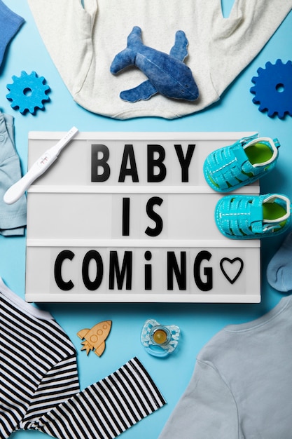 Top view pregnancy announcement with baby items