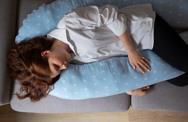 Top view pregnant woman using nursing pillow