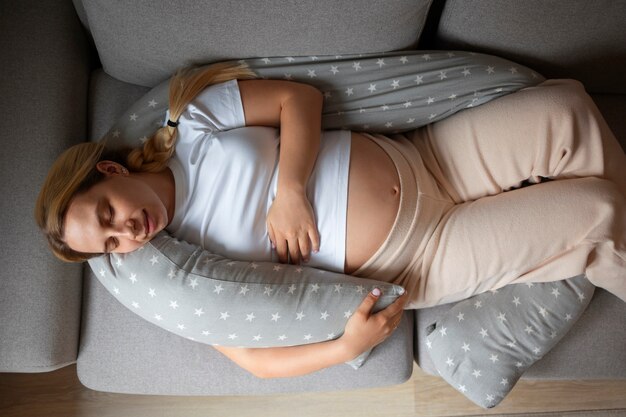 Top view pregnant woman using nursing pillow