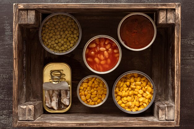 Top view preserved food cans in wooden crate