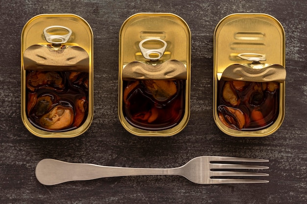 Top view preserved mussels in cans with fork