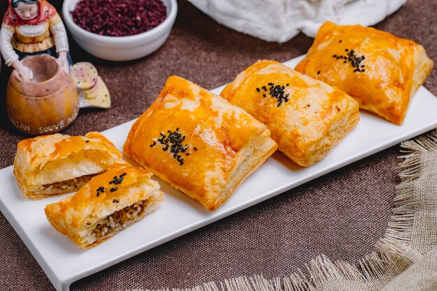 Top view puff pies with meat and rice on a plate