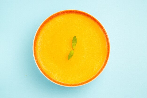 Free photo top view of pumpkin soup inside plate on blue background