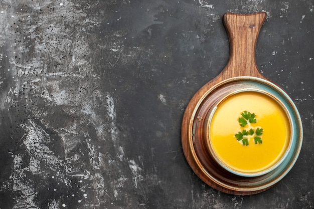 Foto gratuita vista dall'alto della zuppa di zucca all'interno del piatto su uno sfondo scuro