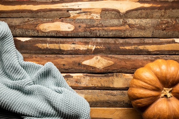 Top view pumpkin with blanket on wooden background