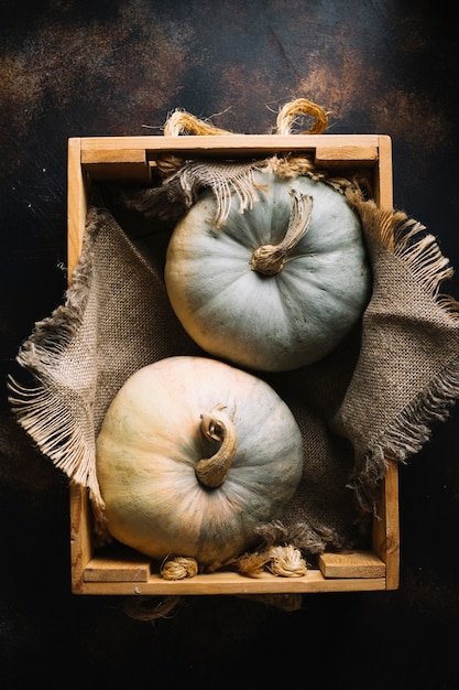 Top view pumpkins in a basket with burlap fabric