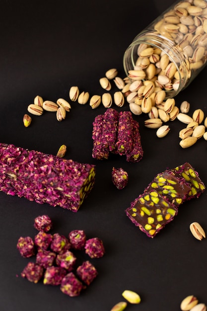 A top view purple candy bar yummy sweet along with peanuts on the dark surface