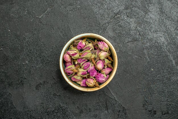 Top view of purple flowers inside pot on black