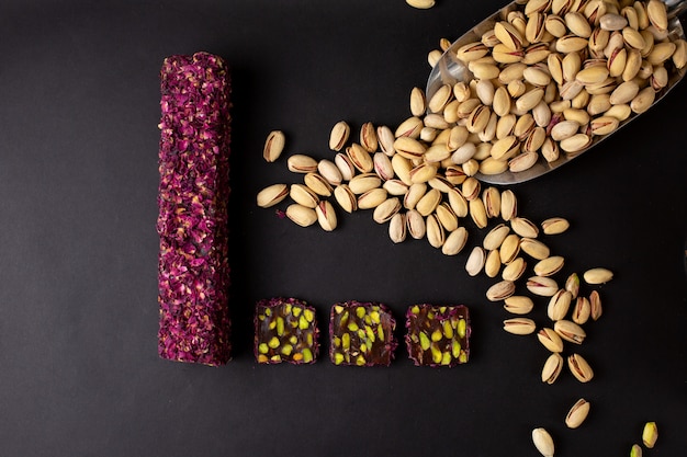 A top view purple green candy bar yummy sliced along with peanuts on the dark desk