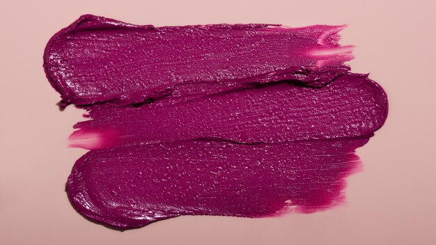 Top view purple lipstick shade on pink background