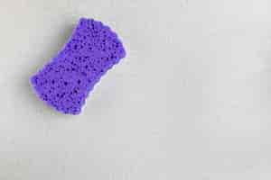 Free photo top view purple sponge on grey background