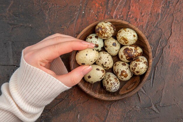 Top view quail eggs inside plate on a dark table