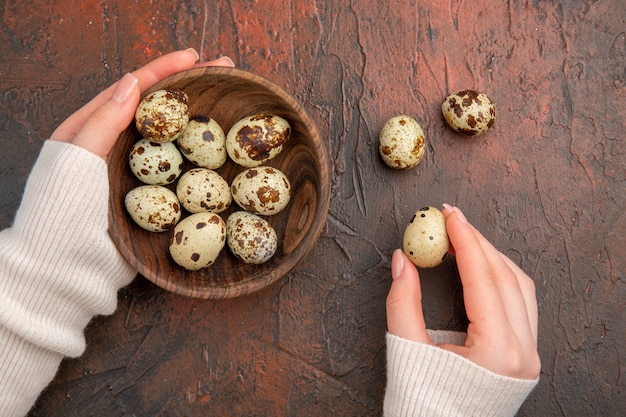 Top view quail eggs inside plate on dark table