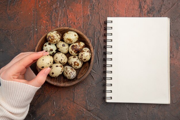 Top view quail eggs inside plate on the dark table